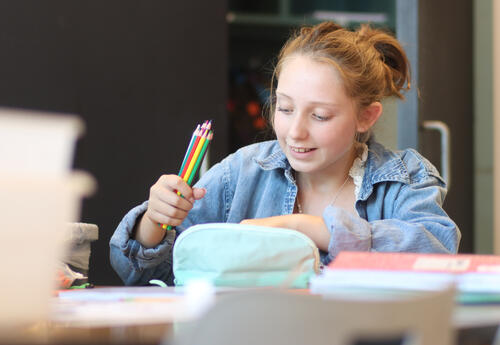 Student smiling while sorting school supplies