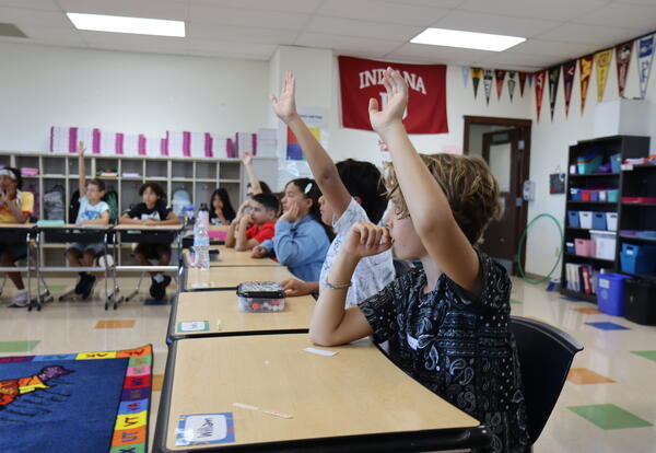 students raising their hands