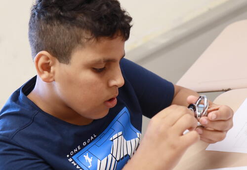 A student practices opening a combination lock.