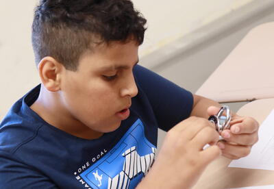 A student practices opening a combination lock.
