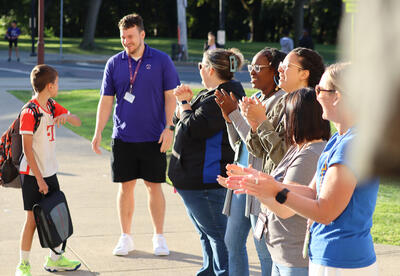 Hackett staff welcoming a student to school