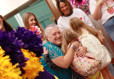A teacher hugs a student at a clap in event.