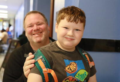 A dad and a student enjoy breakfast together before school begins.