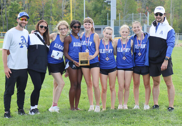 Girls' team and coaches holding second place plaque