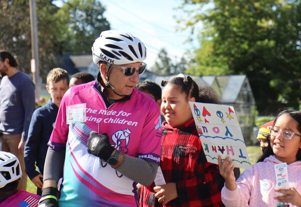 Students cheer on cyclists spreading awareness about missing and exploited children.