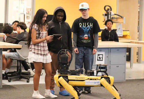 Three students working together to pilot the robot
