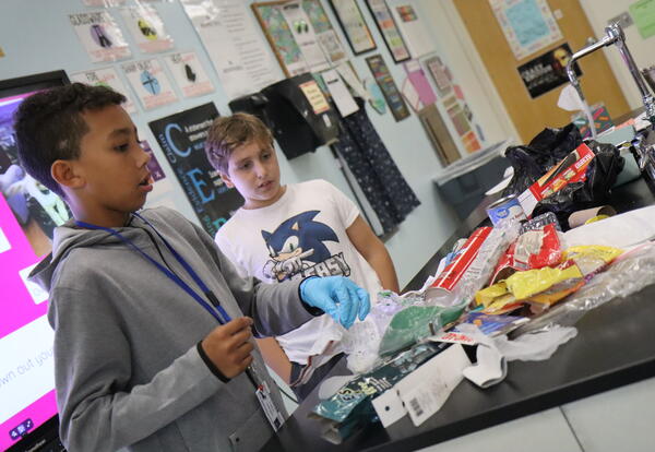 Students sift through trash during a science lab.