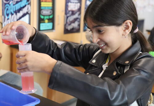A student measures volume during a science lab.