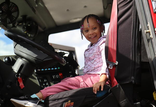 A student sits in the front seat of a fire truck.