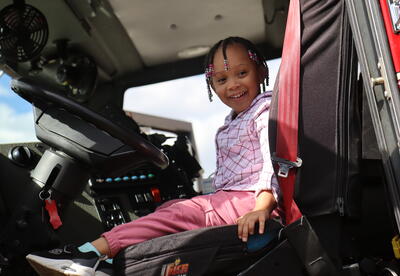 A student sits in the front seat of a fire truck.