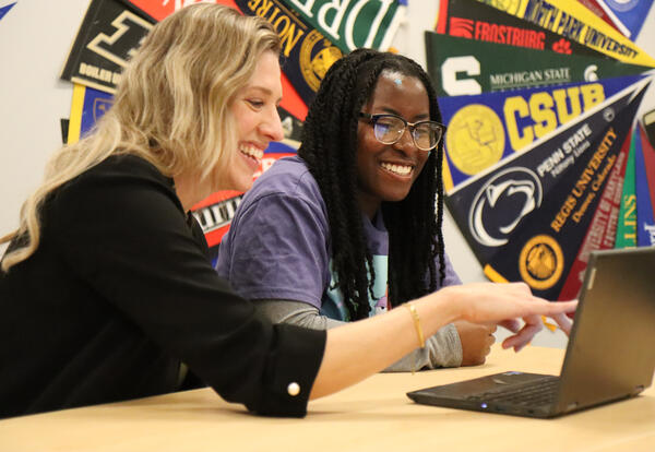 Quinn and Koudoagbo with a laptop in the College and Career Center