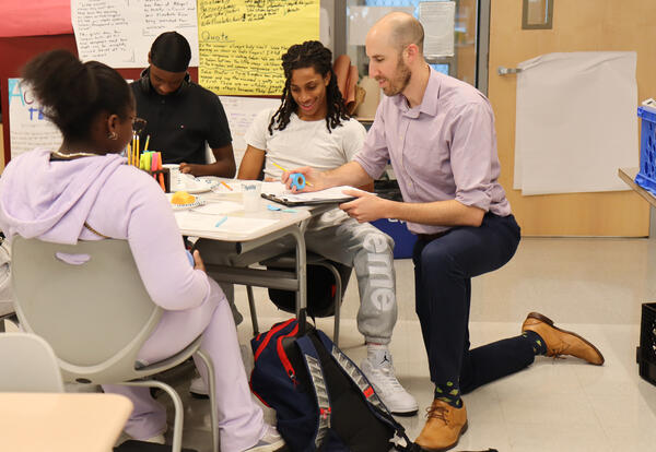 Students discussing lesson with teacher Thomas Rende