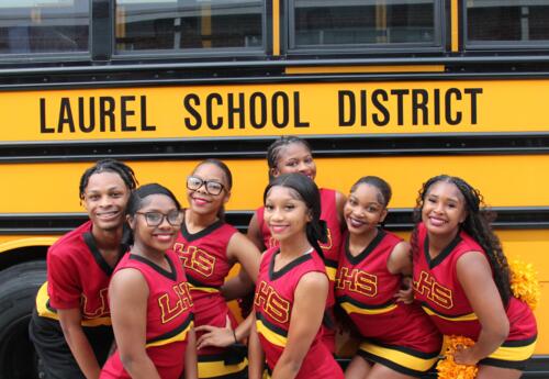 LHS cheerleaders in front of a Laurel School District school bus