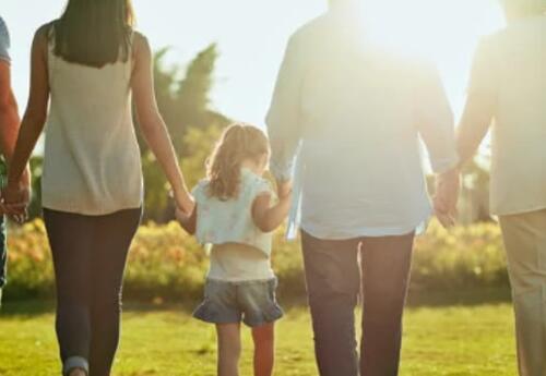 A family walking into the sunset holding hands