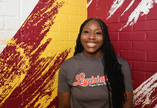 Kayllis Walker smiling with red and yellow background