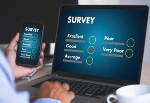 picture of a hand  working a laptop and a cell phone while taking a survey