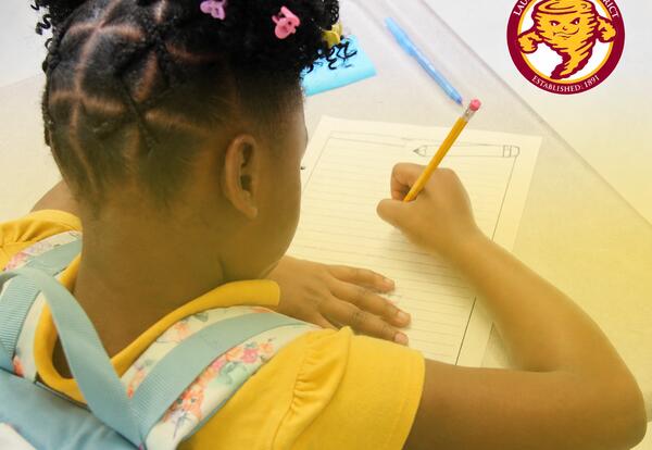A Laurel School District elementary student completes a classroom writing activity at a desk. The district logo appears in the upper-right corner.