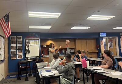 Megan Lavagnino leads a discussion with her 8th grade English students during a 9/11 unit, where students explore articles, video footage, and personal accounts to understand the impact of the attacks.