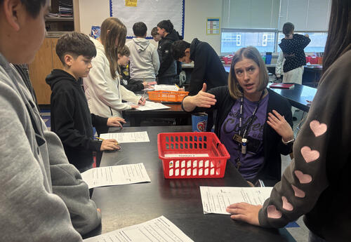 Sterling Junior High science teacher Susan Honaas works with students during a hands-on physics lesson exploring Newton’s First Law of Motion.