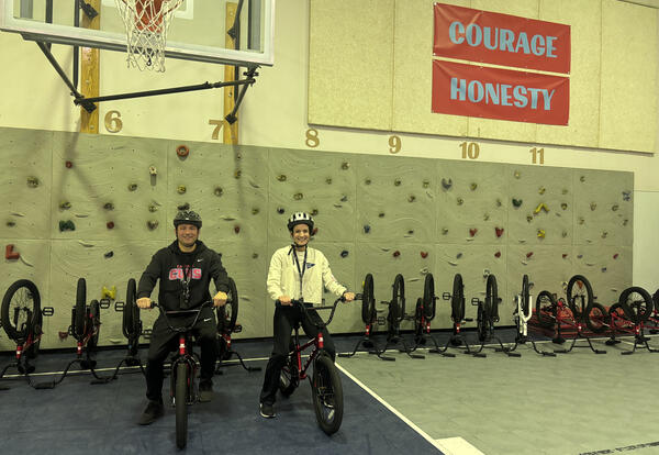 PE teachers Jaime Ramirez Hurtado and Jaime Hotchkiss model safe riding skills for students during Cascade Elementary’s Let’s Go bike safety unit.