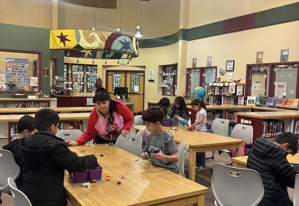 Library ParaEducator Rebecca Cattin guides students through a LEGO challenge at Kenroy Elementary School