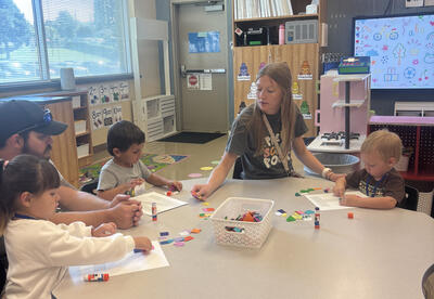 Grace Dorey, Wee Wildcats Preschool teacher at Eastmont High School, guides a student through a hands-on glue stick activity. "My top priority is building a love for learning right from the start," says Dorey.