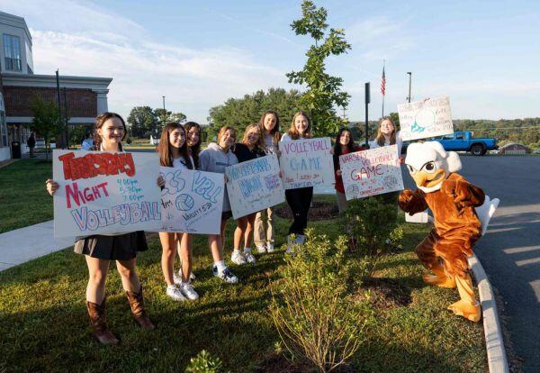 Students Holding Sports Signs with Eagle Mascot