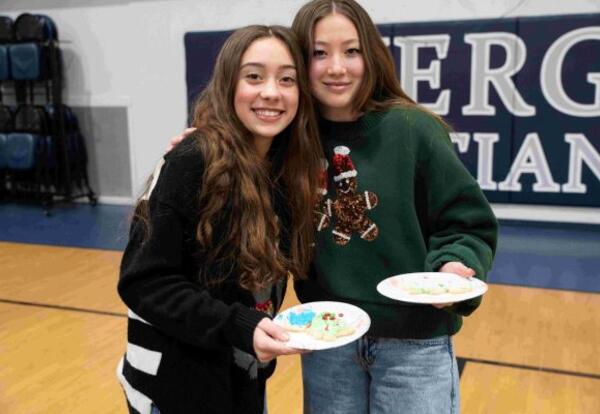 Two girls holding Christmas cookies