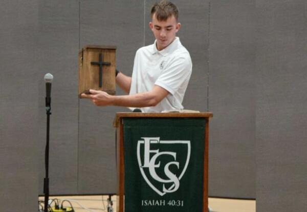 Student Holding a Cross and Reading from the Bible