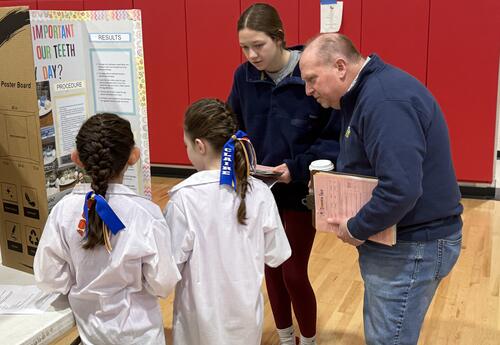 Science Fair judges reviewing student display