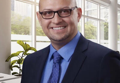 Anthony Salinas, Superintendent of the School City of Hammond, smiling in a suit and tie with an office background