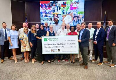 Group Picture Of People With A Huge Check