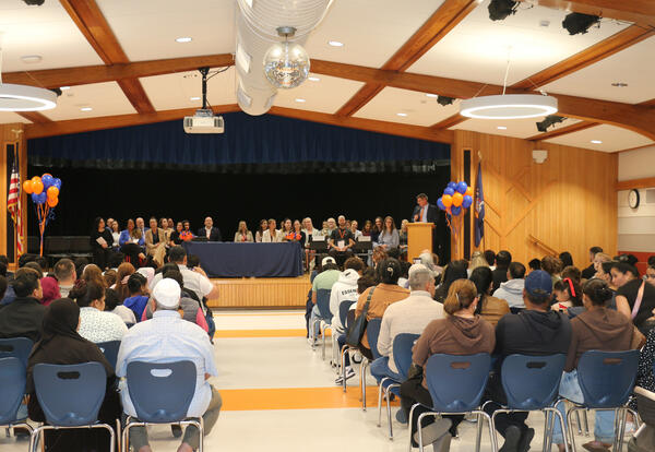 Photo of people sitting in an auditorium and watching a ceremony