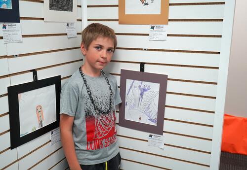 Male student posing with his art