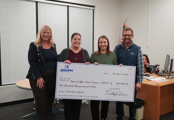 RASP and JE Dunn Representatives smile with large check for 100,000