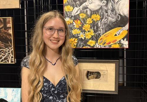 Addison Dahmus in front of her painting, "Her World in Bloom"