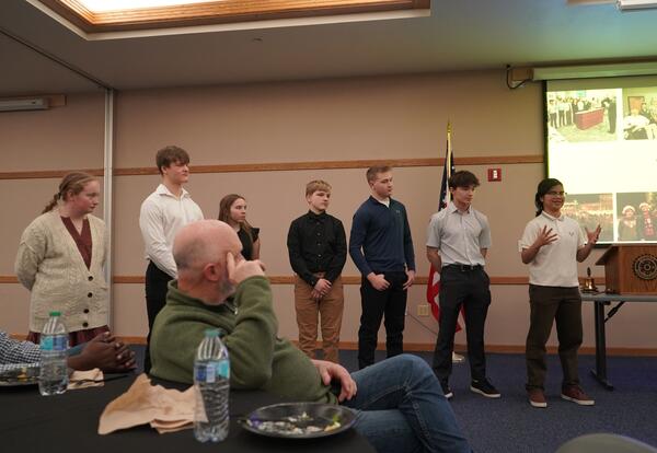 Dickinson high school students standing up and presenting at the rotary club