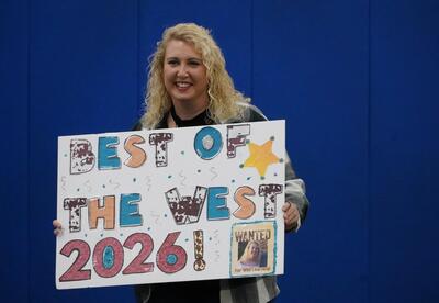 Emily Hoffman winner of Best Elementary School Teacher holding a sign