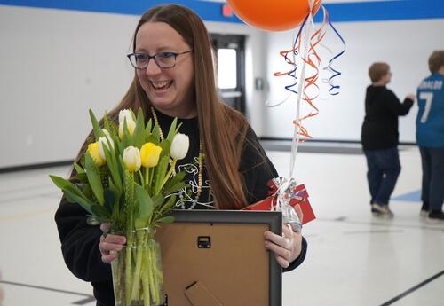 Beth Schmitt holding flowers, balloons and a gift