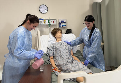 2 Dickinson High School students at a clinic completing training