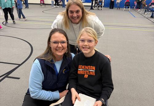 Staff and family members with student as they hold their poem