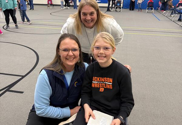 Staff and family members with student as they hold their poem