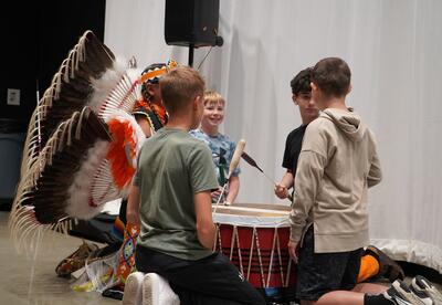 Student gathered around drum ready to play culture song
