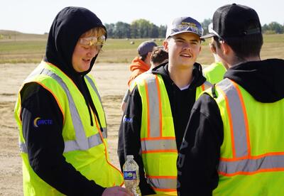 Group of students conversing at job site.
