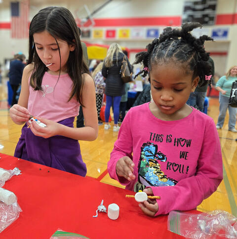 Two girls making a craft