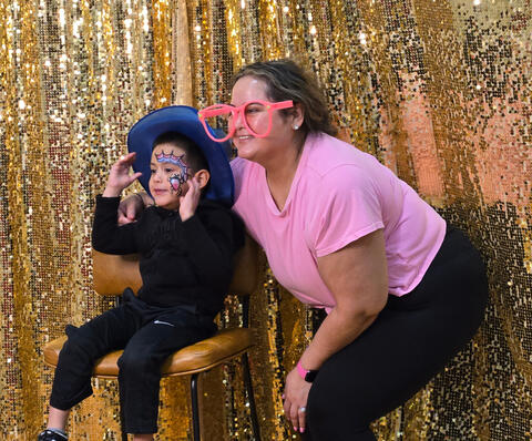 Family posing for the camera with costume hat and glasses
