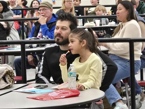Girl and Dad watching the Magic Show Together