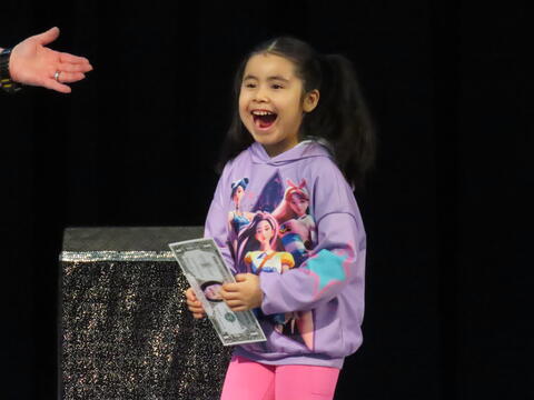 Excited girl getting her gift for participating in the magic show