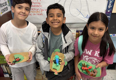 Students show their clay bugs