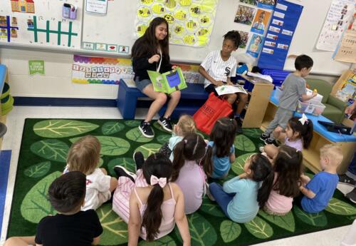 Two students read aloud to a group of younger students as part of Service Learning Day activities.